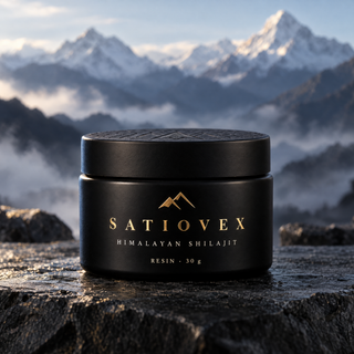 Satiovex Himalayan Shilajit resin in a matte black glass jar with a gold-foil label, standing on dark slate rock with snow-capped Himalayan peaks and mist behind.